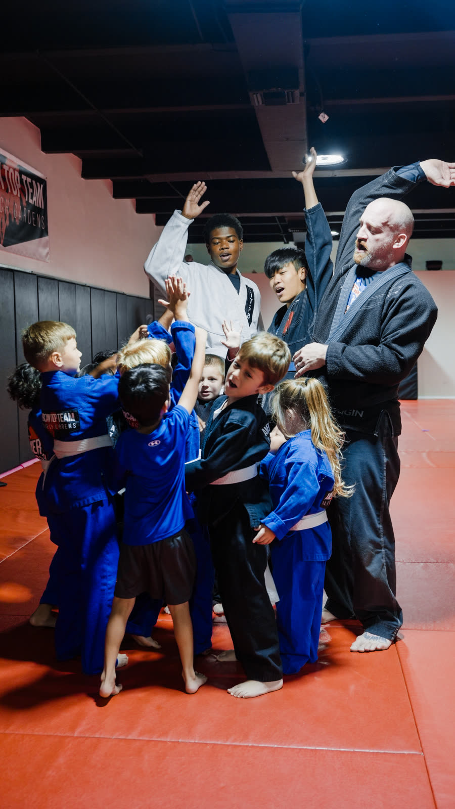 Kids celebrating a high-five at BJJ practice